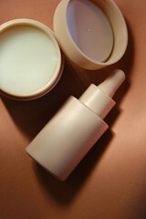 Face cream and serum on a soft beige background.