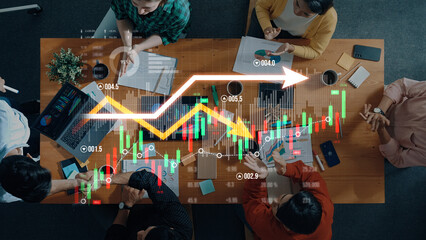 A diverse business team engages in a meeting to analyze financial data using charts and graphs,...