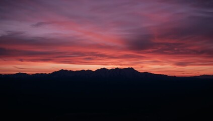 Obraz premium Fiery Horizon Silhouette Vivid Sky Palette with Mountain Ridge Abstract.