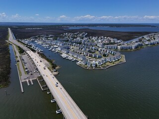 Aerial View Of Washington Baum Bridge Over Calm Water of Roanoke Sound Connecting Roanoke Island to Nags Head on the Outer Banks. Bright blue sky, tranquil water, urban-seaside scene.