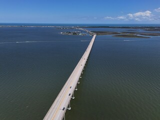 Aerial View Of Washington Baum Bridge Over Calm Water of Roanoke Sound Connecting Roanoke Island to Nags Head on the Outer Banks. Bright blue sky, tranquil water, urban-seaside scene.