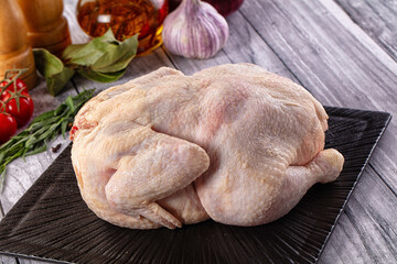 Raw whole chicken over board