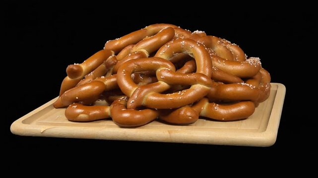 Rotating Stack of Soft Pretzels on Wooden Tray
