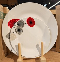 Grupo de platos con dibujos de flores en expositor en estante de comercio