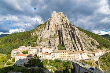 Picturesque town nestled beneath a dramatic mountain cliff. Sisteron, France