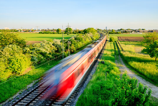 Fast train in green landscape - regional connection between city and countryside - symbol and concept of public transport, commuters, rush hour and Intercity train travel - Munich, Germany