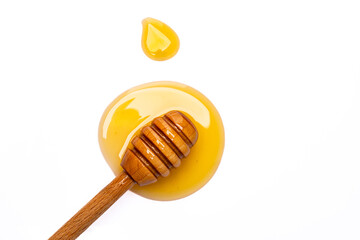Honey dripping from honey dipper  on white background