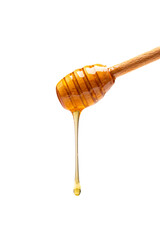 Honey dripping from honey dipper on white background