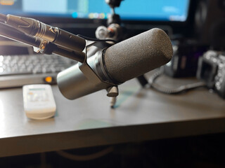 Studio microphone on desk with blurred background and soft lighting. Sound recording, podcast production and creative workspace for voice and music creation.