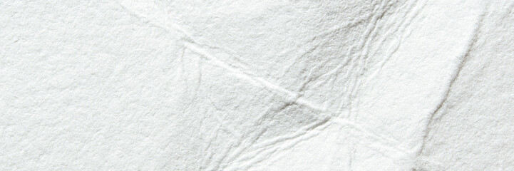 Close-up of textured white paper with subtle fiber patterns and natural creases.