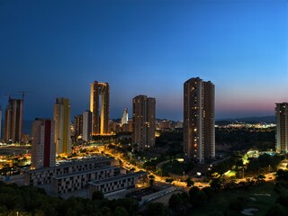 Fototapeta premium A stunning nightscape of urban highrises and illuminated streets full of city life