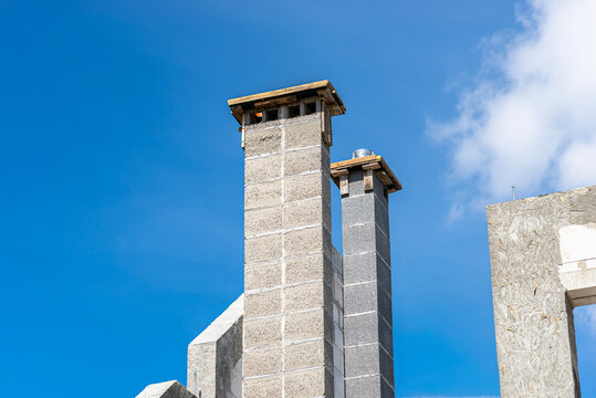 The gable walls are poured with concrete, with visible system chimneys.