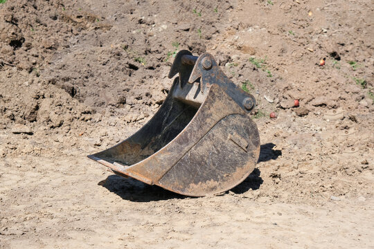 Konzept Erdarbeiten und Landschaftsbau: Seitenansicht einer gro&szlig;en Bagger Schaufel auf einer Baustelle vor Aushub mit viel Freiraum f&uuml;r Textgestaltung
