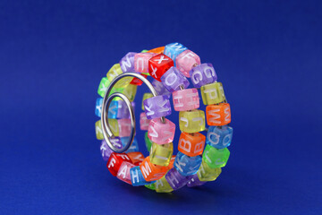 Learning curve, colorful cubes with letters on a metal spiral