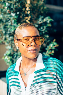 Stylish woman wearing glasses outdoors.
Street portrait of a fashionable black woman with glasses and short hair.
