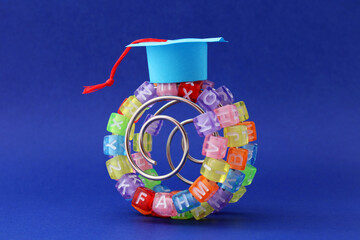 Graduate hat on a learning curve, colorful cubes with letters in a metal spiral