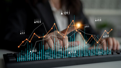 A business professional engaged in financial analysis, focusing on charts and graphs displayed on a screen. The image captures the essence of data-driven decision-making. Scalp