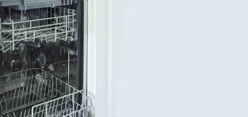 Open modern stainless steel dishwasher with empty racks and clean interior in kitchen setting.
