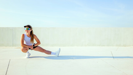 Stretches on an outdoor surface with a focus on fitness and personal well-being