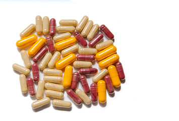 Assorted capsules on white background - red, yellow, and beige pills