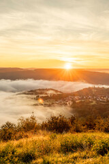 Vibrant sunrise over the Rhine River near Bad Salzig creates a breathtaking morning scene with mist and lush greenery