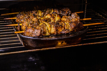 Marinated shashlik (or shish kebab) preparing on a wooden skewers in electric oven