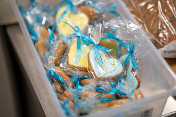 Heart-shaped cookies decorated with icing in transparent wrapping inside a box, concept of sweetness and handmade gift.