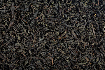 Dry black tea background pattern, top view. Dried black tea leaves texture. Hot drink ingredient.