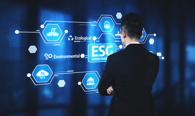 A business professional stands in front of a digital display showcasing ESG elements, emphasizing the importance of sustainability and responsible governance in modern enterprises. Tessel