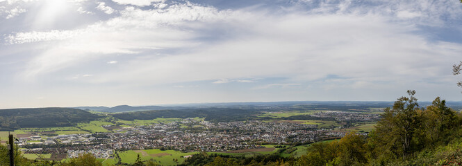 Scenic view of a vast landscape with town and hills under a bright sky during the daytime