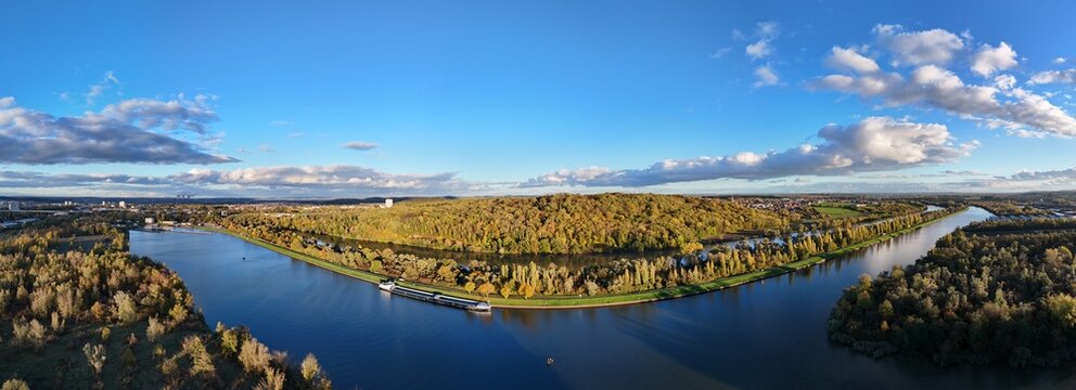vue a&eacute;rienne panoramique des bords de la Moselle entre Thionville et Metz, pr&egrave;s d'Illange. Paysage d'automne en Lorraine, avec un ciel bleu mais nuageux et des arbres aux couleurs dor&eacute;es