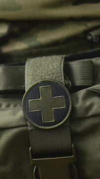 Camouflaged army soldier on a stealth mission. Close-up on the military equipment with first aid kit. War recon training