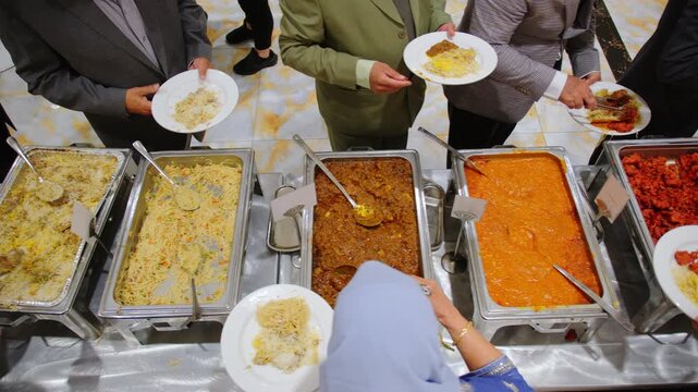 Close up shoot of the guests enjoying the Indian or Pakistan catering buffet dishes with variety of the colorful food at the venue on event. Above view