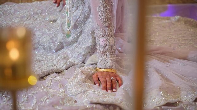 The bride, dressed in a traditional Pakistani wedding outfit, poses for the photographers