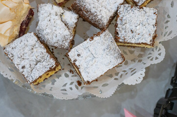 Homemade layered chocolate and vanilla cream cake slices with powdered sugar on a glass plate.