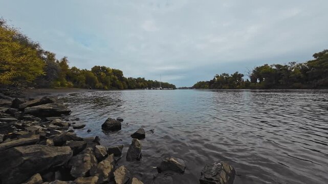 Wide Angle of Autumn River Shoreline with Distant Boats Moored in the Channel