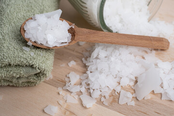 Close-up of magnesium salt flakes. Spa body care and magnesium therapy. White salt, cotton towels, eco-friendly products for home relaxation spa.