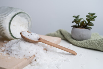 Close-up of magnesium salt flakes. Spa body care and magnesium therapy. White salt, cotton towels, eco-friendly products for home relaxation spa.