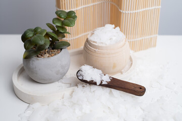 Close-up of magnesium salt flakes. Spa body care and magnesium therapy. White salt, cotton towels, eco-friendly products for home relaxation spa.
