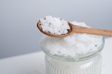 Close-up of magnesium salt flakes. Spa body care and magnesium therapy. White salt, cotton towels, eco-friendly products for home relaxation spa.