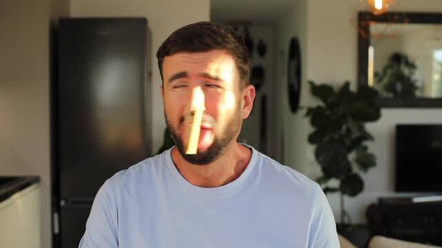 Man with clothespin blocking his nostrils 