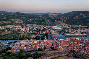 Fototapeta premium Bosa historic city aerial drone view of colorful buildings at sunset in Sardinia, Italy