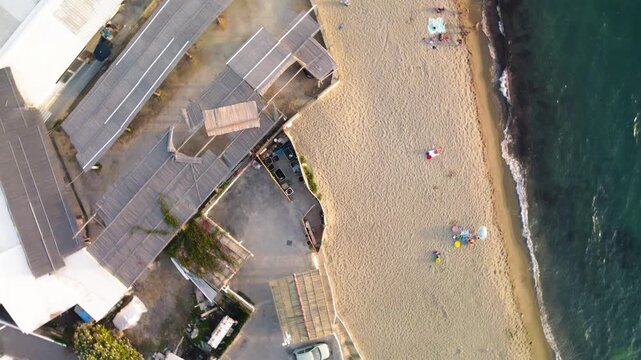 Overhead aerial view of Ischia Citara Beach at sunset with pools and sand