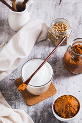 Miso-Spiked latte in a glass and a bowl of miso paste on the table vertical view
