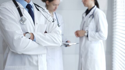 Medical team of doctors collaborating and consulting in a bright hospital setting, showcasing...