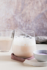 Cloudy pink matcha with coconut water in a glass on the table vertical view