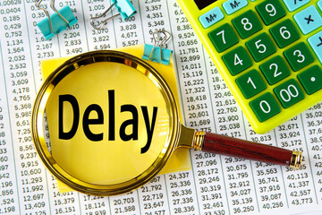 DELAY - word under a magnifying glass on the background of a calculator and a sheet with numbers