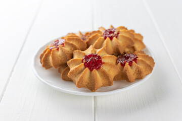 Fresh Homemade Butter Cookies on White Plate with Raspberry Jam Topping