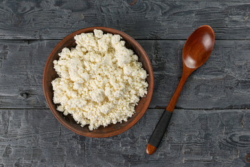 Rustic Cottage Cheese in Wooden Bowl with Spoon on Dark Wooden Table