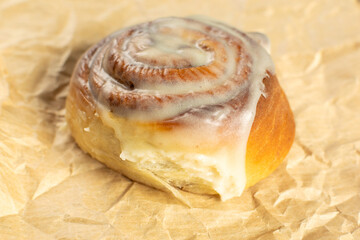 Fresh Cinnamon Roll with Icing on Parchment Paper - Delicious Pastry Photography